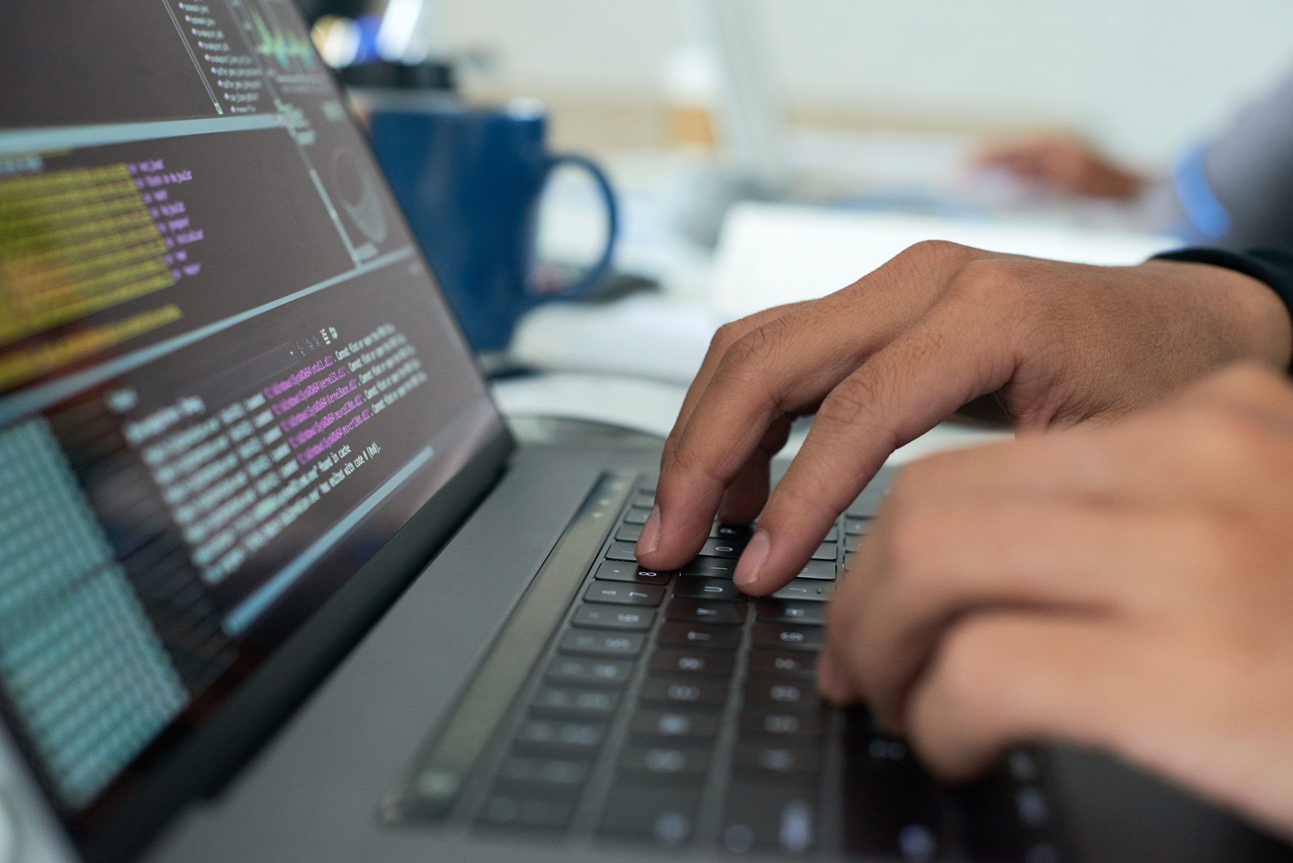 mains tapant sur un clavier avec du code pour assurer le support niveau 0 et 1